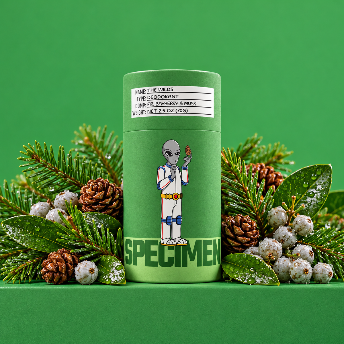 Specimen The Wilds natural deodorant in a green paper tube with fir branches, pinecones and bayberries