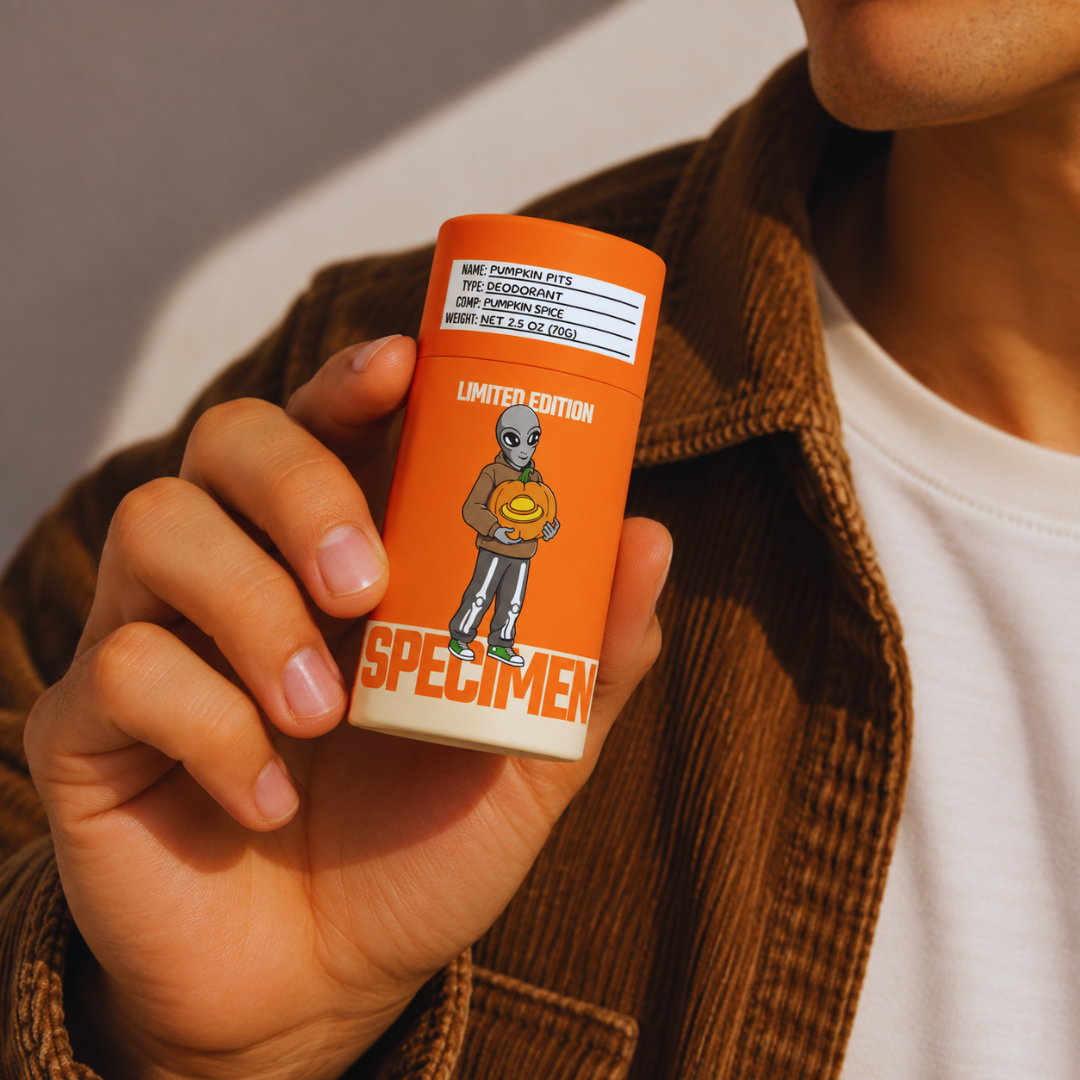 Editorial-style lifestyle image showing Specimen’s Pumpkin Pits deodorant held in a male hand near the model’s upper body. The natural skin tones, soft lighting, and minimal styling emphasize the product’s fresh, playful, and modern aesthetic.
